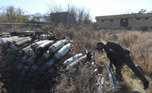 Un homme examine le 7 décembre 2014 des bombes entreposées à Jangalak, au sud de Kaboul