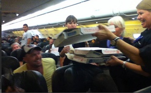 Photo de Logan Marie Torres montrant des pizzas livrées aux passagers bloqués d'un vol de la compagnie Frontier Airlines, le 7 juillet 2014.