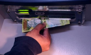 Une personne retire de l'argent à un distributeur à Caracas