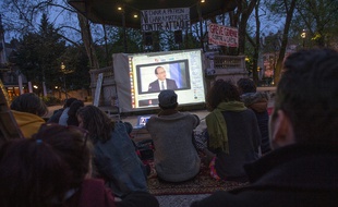 Des manifestants regardent l'intervention télévisée de François Hollande lors de la Nuit debout à Besançon, le 14 avril 2016.