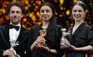 Elio Germano (à g.) et Paula Beer (à dr.), Ours d'argent du meilleur acteur et de la meilleure actrice 2020 entourent Baran Rasoulof venue recevoir l'Ours d'or au nom de Mohammad Rasoulof.