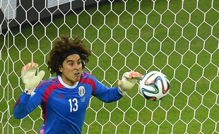 Mexico's goalkeeper Guillermo Ochoa saves an attempt at goal during a Group A football match between Brazil and Mexico in the Castelao Stadium in Fortaleza during the 2014 FIFA World Cup on June 17, 2014. AFP PHOTO / FABRICE COFFRINI