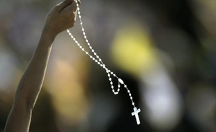 Une croyante arbore un chapelet, lors de la visite du Pape François près d'Asuncion, au Paraguay, le 12 juillet 2015