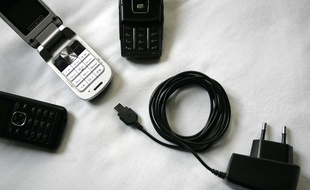 Des téléphones portables de différentes marques et un chargeur