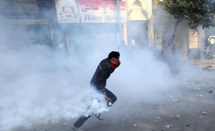 Un manifestant dans la fumée d'une bombe lacrymogène, dans une rue adjacente à la place Tahrir, au Caire, le 22 novembre 2011.