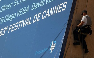 Haute voltige pour les ouvriers en charge de fixer l'affiche officielle de la 63ème édition au Palais des Festivals.