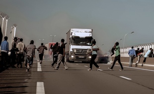 Des migrants tentent de monter dans des camions sur l'A16.