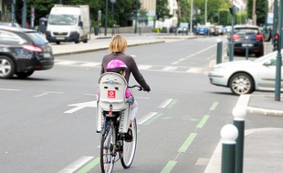 Illustration d'une cycliste transportant son enfant à vélo, ici dans les rues de Rennes.