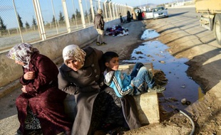 Des Syriens attendent au point de passage d'Oncupinar, près de la ville de Kilis en Turquie, de pouvoir retourner en Syrie, le 9 février 2016