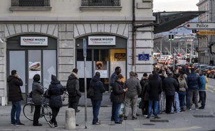 People queue to change their Swiss francs at a currency exchange office on January 15, 2015 in Geneva. In a shock announcement on January 15, Switzerland's central bank said it was ending a three-year bid to artificially hold down the value of the Swiss franc against the euro, in a move that immediately sent the safe haven currency soaring. Following the announcement, the Swiss franc strengthened 29 percent to 0.8517 against the euro. AFP PHOTO / FABRICE COFFRINI