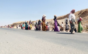 Des réfugiés yazidis franchissent la frontière de l'Irak vers la Syrie, le 13 août 2014.