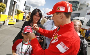Le sextuple chamion du monde de formule 1 Michael Schumacher signe la casquette d'un enfant, au grand prix de Nürburgring, le 22 juillet 2007