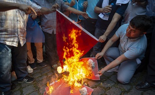 Des soutiens des Ouïghours brûlent un drapeau chinois et un portrait du président de la Chine Xi Jinping lors d'une manifestation à Istanbul devant le consulat chinois. Istanbul, Turquie, le 01/10/2019