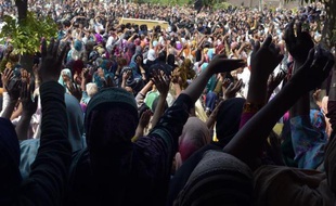 Des chrétiens prient pour leurs morts sous haute surveillance le 17 mars 2015 à Lahore, la deuxième ville du Pakistan, après une attaque des talibans contre des églises
