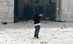 Un jeune palestinien lance une pierre en direction de la police israélienne, près de la mosquée d'Al-Aqsa, vendredi 5 mars 2010.