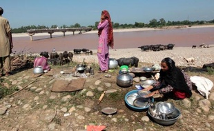 Des villageois installés près du fleuve Tawi dont la crue a détruit une partie du pont, le 9 septembre 2014 à Phallian Mandaal, en Inde