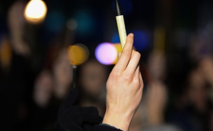 Une manifestante brandi un stylo pour exprimer son soutien aux victimes de l'attenta contre Charlie Hebdo le 7 janvier 2015 à Bruxelles
