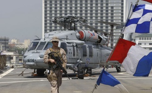 Un marine américain patrouille sur le navire de commandement USS Blue Ridge, qui participe aux recherches, le 18 mars 2014.