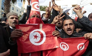 Une Tunisienne s'accroche à la jambe d'un soldat pour se protéger lors d'une manifestation à Tunis, le 20 janvier 2011.