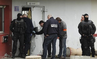 Des enquêteurs devant une porte de la prison de Sequedin détruite à l'explosif lors de l'évasion de Rédoine Faïd, le 13 avril 2013.