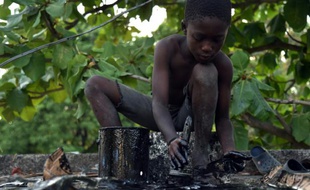 Samuel peint un objet en fer forgé, au village de Noailles, en périphérie de Port-au-Prince, le 17 avril 2016