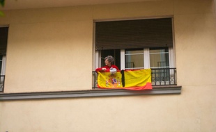 Une femme à son balcon à Madrid protestant contre le maintien du confinement, le 15 mai 2020.