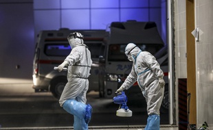 A Wuhan, deux personnels soignants se préparent à transporter des malades du Covid-19, le 3 mars 2020.