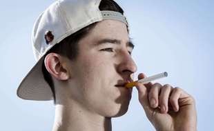 Un adolescent avec une cigarette électronique.