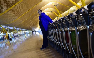 Un SDF bulgare, Valentin Giorgiev, pose devant des chariots porte-bagages à l'aéroport de Madrid le 30 décembre 2014