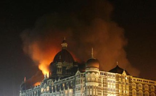 Smoke rises from the Taj Hotel in Mumbai November 27, 2008. Gunmen killed at least 80 people in a series of attacks in India's financial capital Mumbai and troops began moving into one of two five-star hotels on Thursday where Western hostages were being held, local television said. REUTERS/Arko Datta (INDIA)