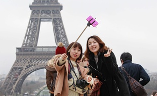 Des touristes avec une perche à selfie, à Paris le 6 janvier 2015