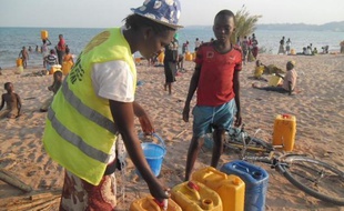 Une volontaire de l'ONG Solidarité Internationale décontamine de l'eau qui pourrait transmettre le choléra, le 12 septembre 2014 à Kalemie au Congo