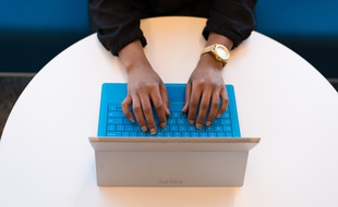 Illustration d'une femme assise, devant une tablette