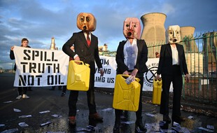 Barbouillés de pétrole et avec un jerrican d'essence en guise de tête, des militants climatiques du groupe Ocean Rebellion, manifestent devant la raffinerie et l'usine pétrochimique d'INEOS à Grangemouth, en Écosse, en marge de la COP26, le 2 novembre.
