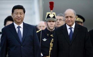 Le président chinois Xi Jinping et le ministre des Affaires étrangères français Laurent Fabius à l'aéroport Saint-Exupéry à Lyon le 25 mars 2014