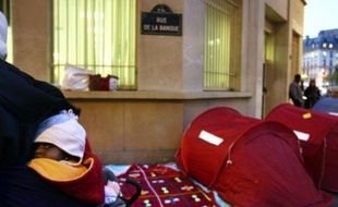 Quelque 200 personnes se sont réunies mardi soir rue de la Banque (IIème) à Paris pour une "nuit de la solidarité" avec les familles qui campent sur les trottoirs depuis le 3 octobre pour exiger leur relogement.