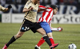 Olympique Marseille's Hatem Ben Arfa (L) challenges Atletico Madrid's Ever Banega during their Champions League soccer match at the Velodrome stadium in Marseille December 9, 2008. REUTERS/Jean-Paul Pelissier (FRANCE)