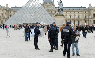 Des policiers patrouillent devant le Louvre à Paris le 11 avril 2013 pour lutter contre des bandes de pickpockets qui s'attaquent aux touristes.