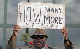 Le révérend Arthur Prioleau brandit une pancarte indiquant: «Combien d'autres encore?» lors d'une manifestation devant la mairie de North Charleston, en Caroline du Sud, le 8 avril 2015, après la mort de Walter Scott, abattu par un policier blanc.