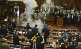 Les parlementaires se dispersent alors qu'un nuage blanc de gaz lacrymogène envahit le Parlement du Kosovo, le 15 octobre 2015 à Pristina