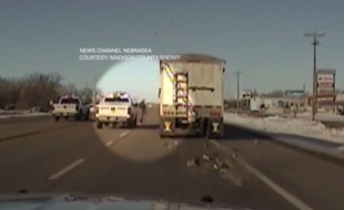 Un policier se jette à bord d'un camion en marche pour l'arrêter.