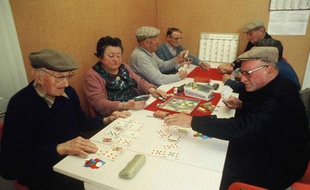 Des seniors jouent aux cartes dans un club du troisième âge.