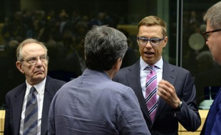 Alexander Stubb (à d.), le ministre finlandais des Finances, s'entretient avec son homologue grec Euclide Tsakalotos sous les yeux de l'Italien Pier Carlo Padoan (à g.) à l'ouverture de l'Eurogroupe à Bruxelles, le 12 juillet 2015