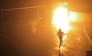 Un manifestant s'enfuit le 15 février 2016 après l'explosion d'un engin incendiaire à l'intérieur de la cour de la gendarmerie à Corte, en Corse