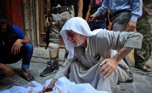 A Alep, le 11 juillet 2014, un homme pleure son fils tué lors d'affrontements avec les forces du régime, alors que l'observatoire syrien des droits de l'homme estime à 170.000 le nombre de morts depuis le début du conflit syrien, dans son dernier bilan