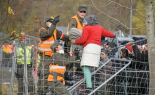 Des militaires autrichiens empêchent une femme tenant son bébé dans les bras de passer un grillage alors qu'elle tente de traverser la frontière austro-slovène depuis Sentilj, en Slovénie, le 30 octobre 2015