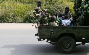 Un véhicule militaire transportant des hommes ligotés circule le 11 décembre 2015 dans le quartier de Musaga, à Bujumbura