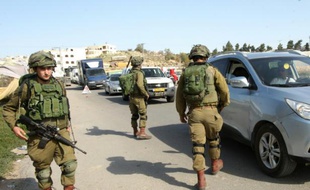 Des soldats israéliens contrôlent les véhicules à l'entrée de la ville de Hébron, le 23 novembre 2015 en Cisjordanie