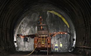 Des ouvriers travaillent dans la galerie de reconnaissance de Saint-Martin-de-la-Porte, appelée à devenir un des tubes du futur tunnel transalpin de 57 km de la LGV Lyon-Turin, le 6 mai 2015 dans la vallée de la Maurienne