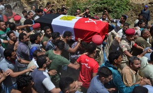 Des personnes en deuil portent le cercueil d'un soldat égyptien lors de ses funérailles dans le village d'Abwan, dans la province de Minya, le 1er mai. L'hommea été tué dans une explosion visant un véhicule blindé près de Bir al-Abed dans le Nord du Sinaï.